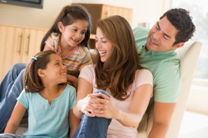 Family sitting in living room smiling